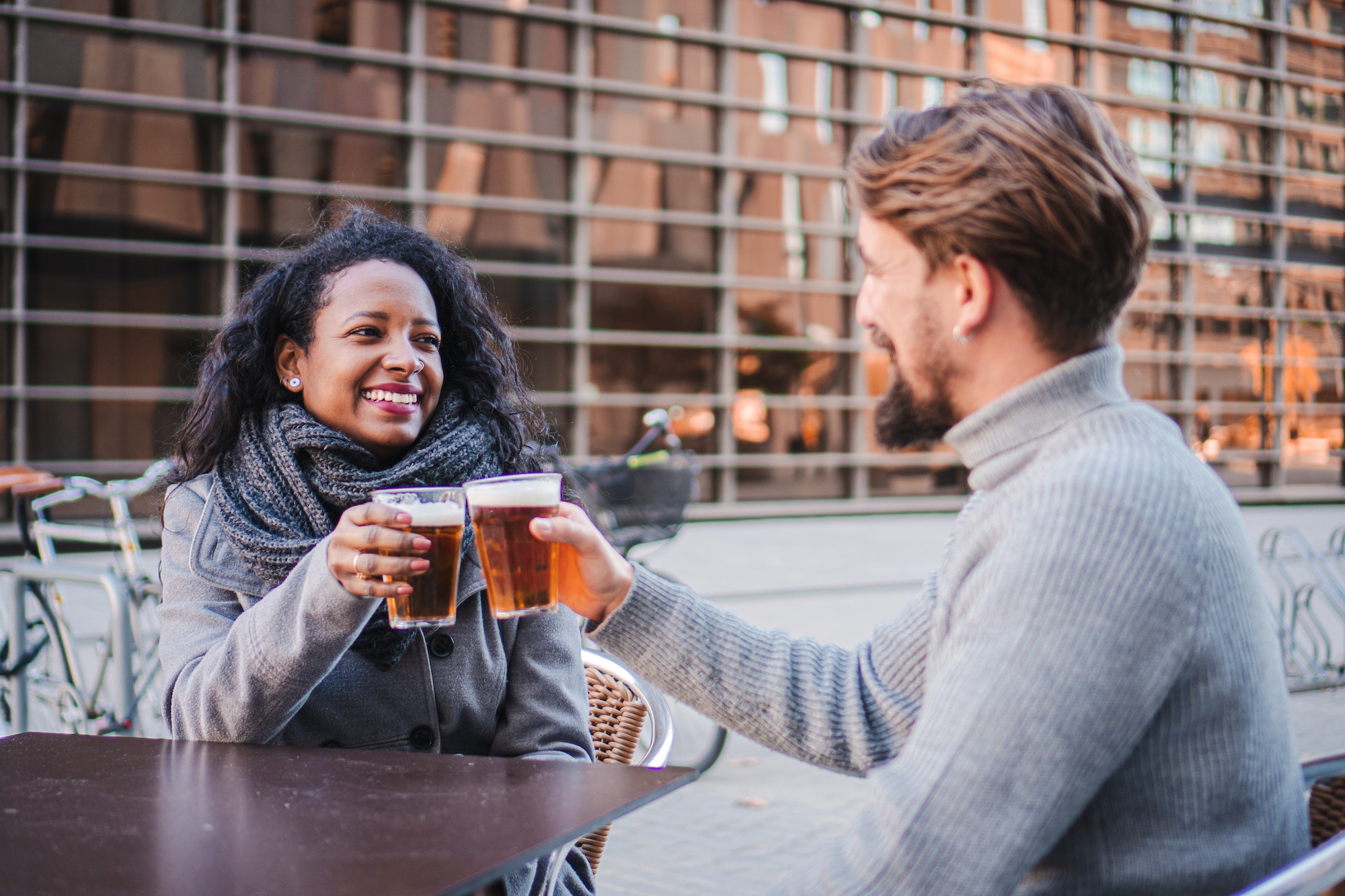 young-business-couple-drinking-beer-talking-and-raising-toast-at-city-pub-terrace-lifestyle.jpg